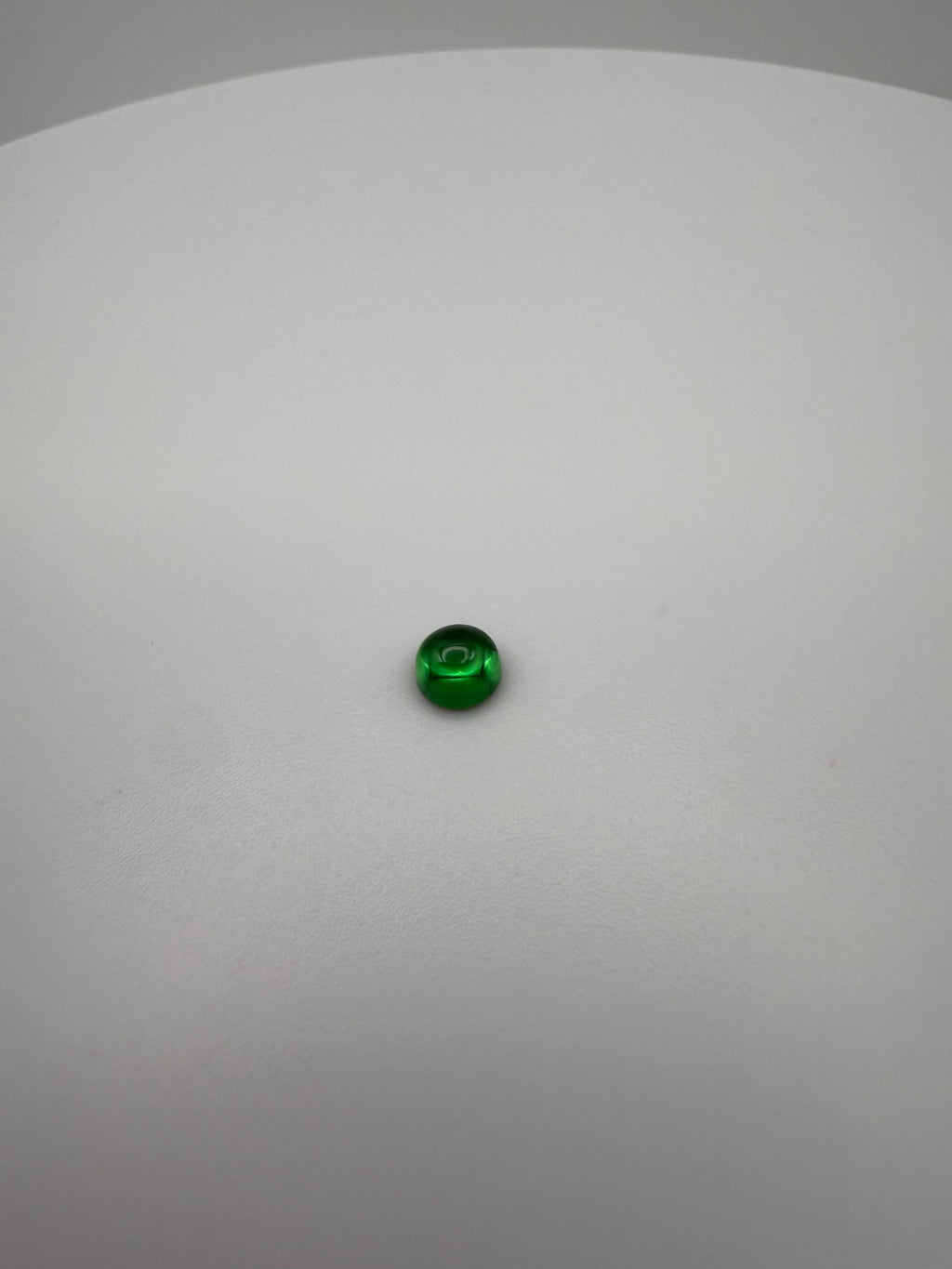 round green cabochon gemstone on a smooth white surface