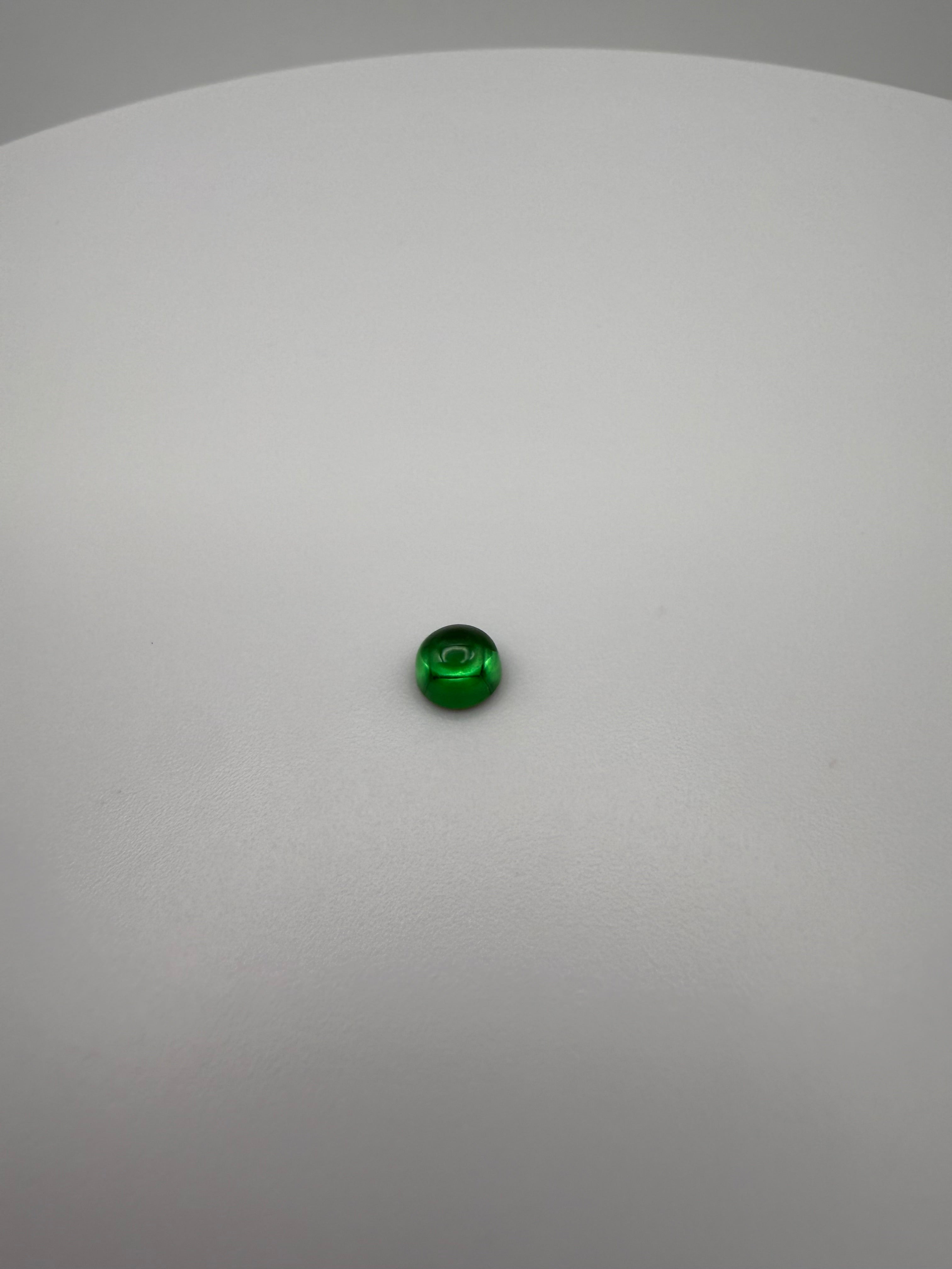 round green cabochon gemstone on a smooth white surface