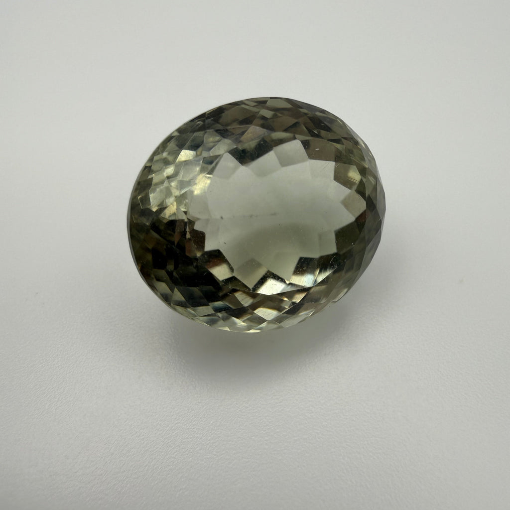 macro view of 16.48ct pale green prasiolite oval faceted gemstone showcasing brilliant facets on a white background