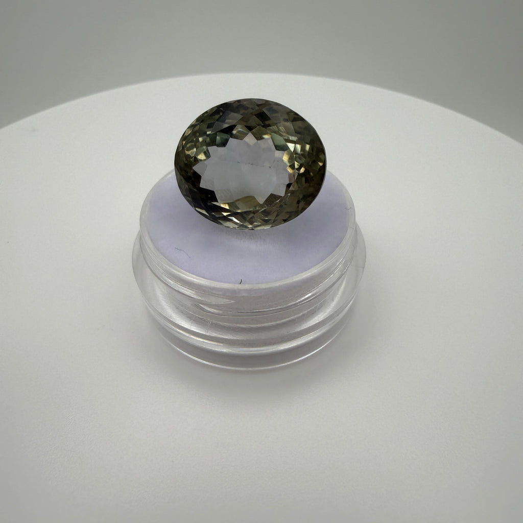 16.48ct pale green prasiolite oval faceted gemstone on a clear display stand against a white background