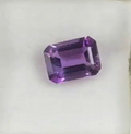 macro view of 1.44ct rectangular faceted violet amethyst gemstone on white background