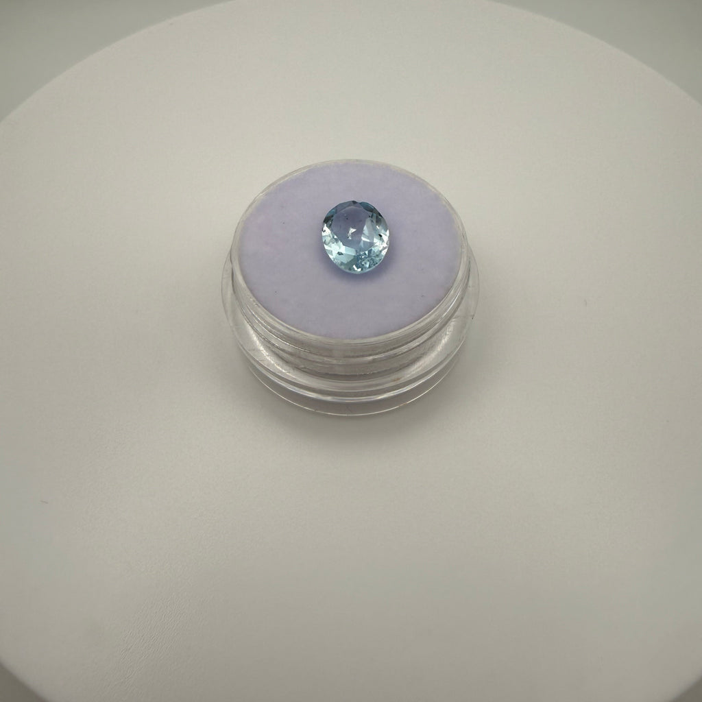 oval faceted 2.05ct Swiss Blue Topaz gemstone on purple velvet in clear gem holder