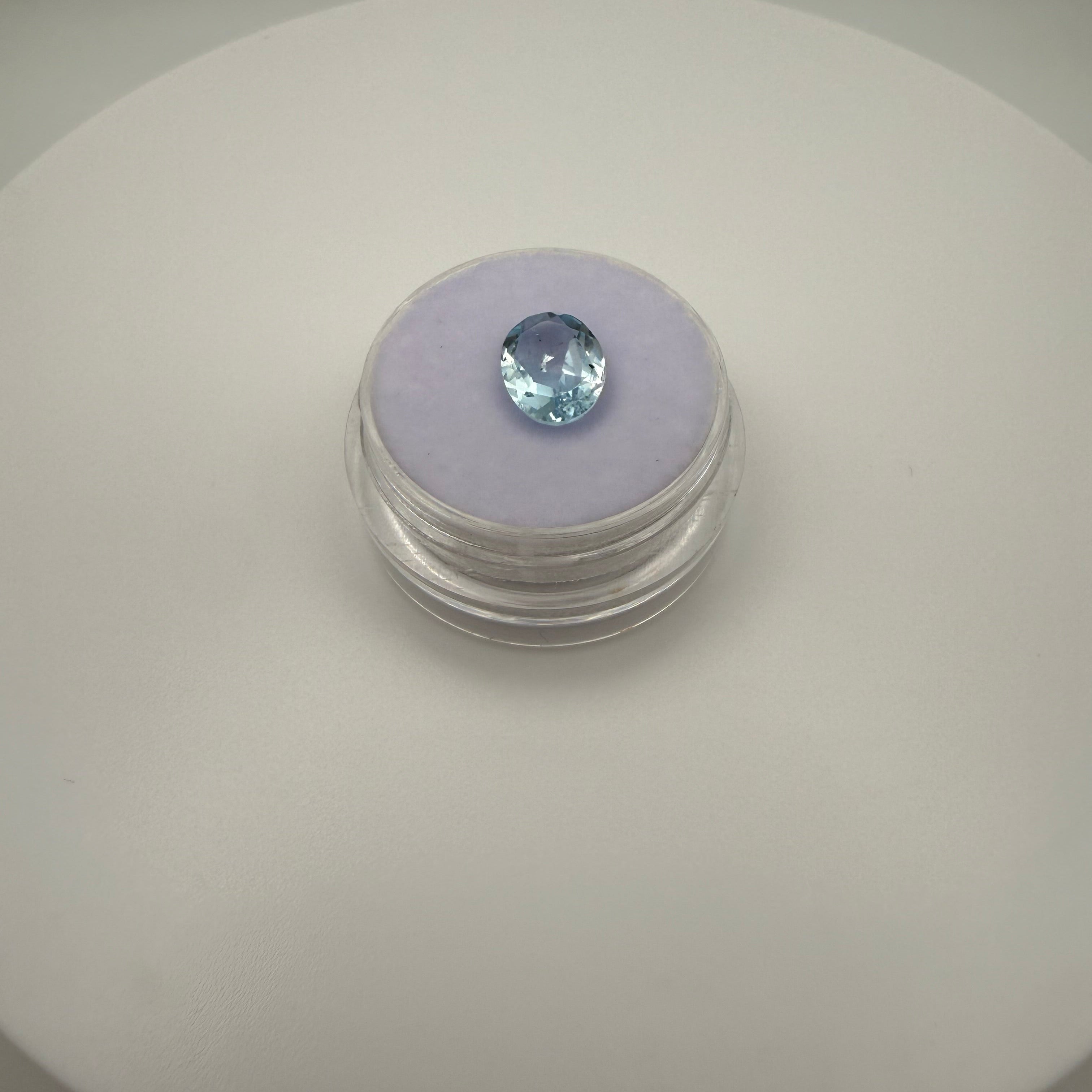 oval faceted 2.05ct Swiss Blue Topaz gemstone on purple velvet in clear gem holder