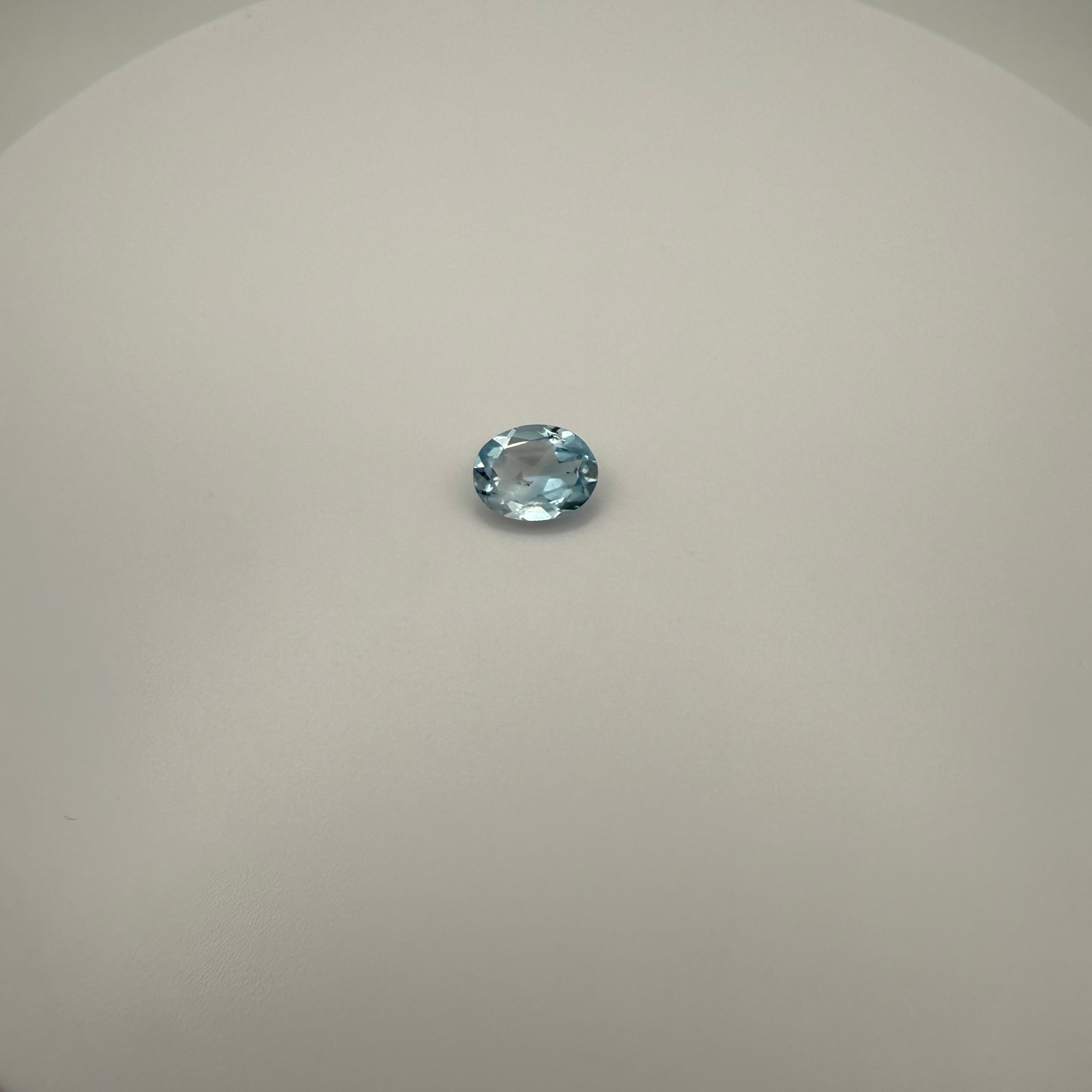 oval faceted 2.05ct Swiss Blue Topaz gemstone on smooth white surface