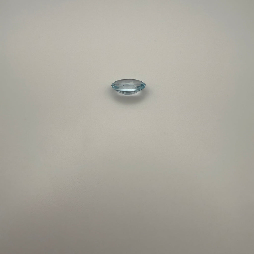 oval faceted 1.95ct Swiss Blue Topaz gemstone on a light background