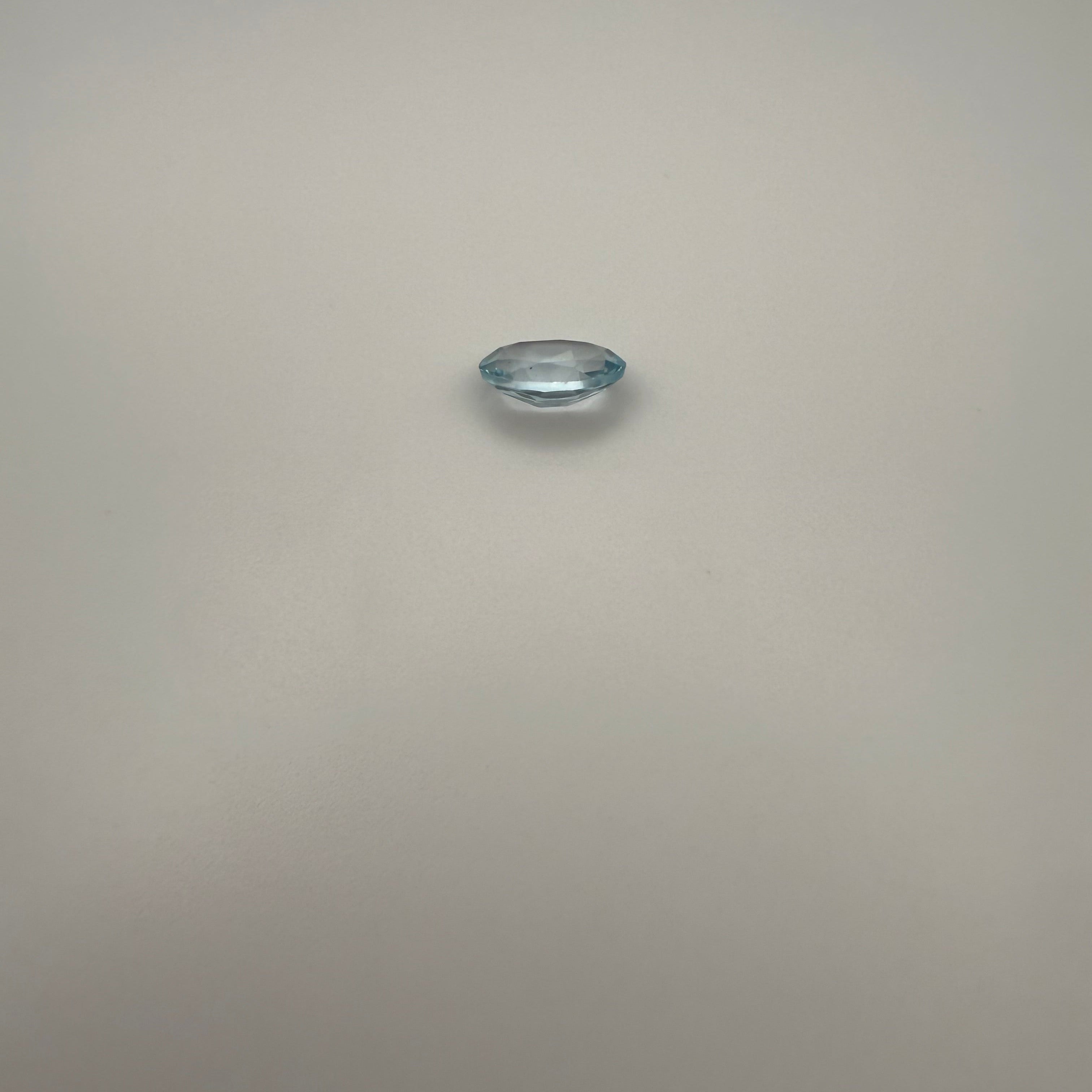 oval faceted 1.95ct Swiss Blue Topaz gemstone on a light background