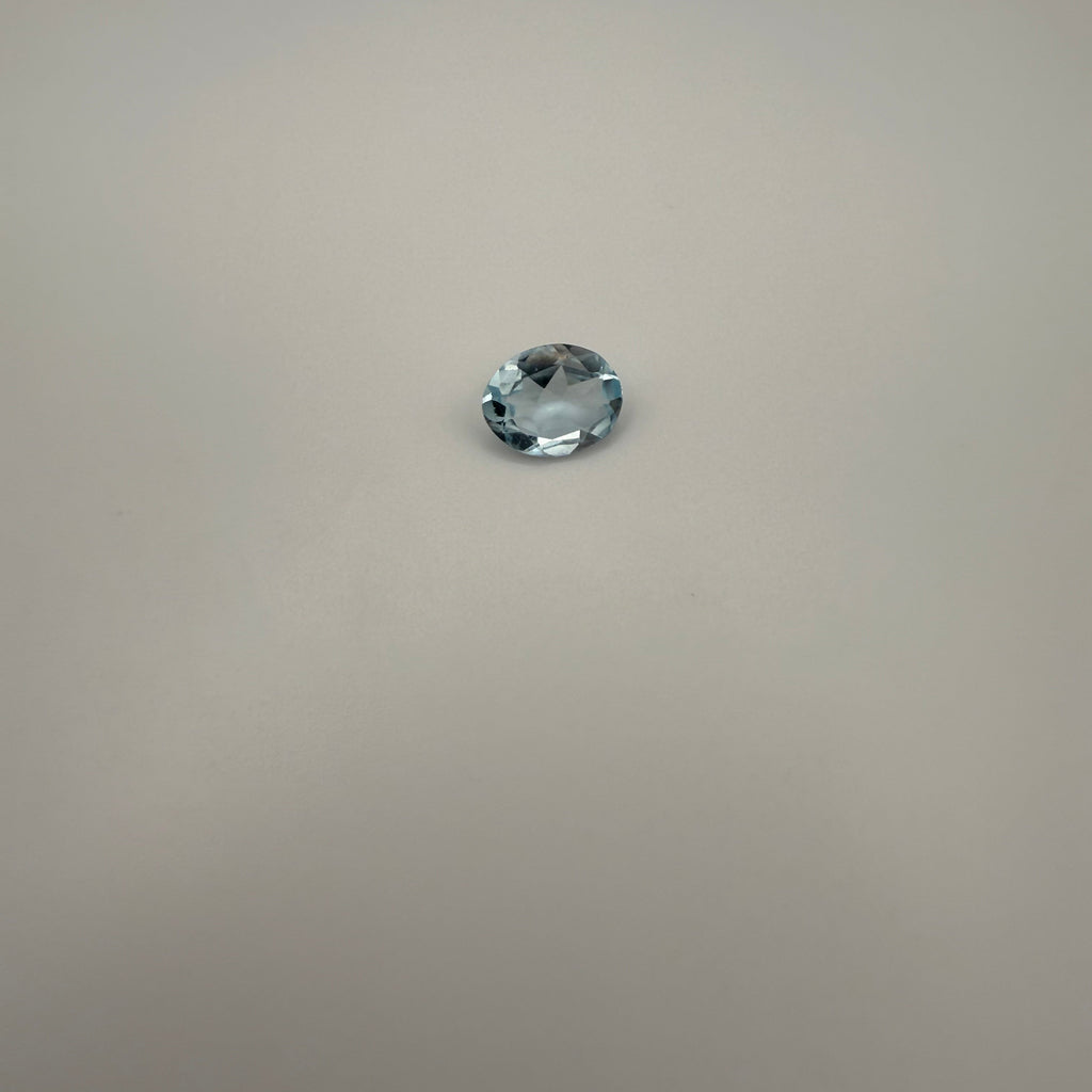 oval faceted 1.95ct Swiss Blue Topaz gemstone on a smooth neutral background