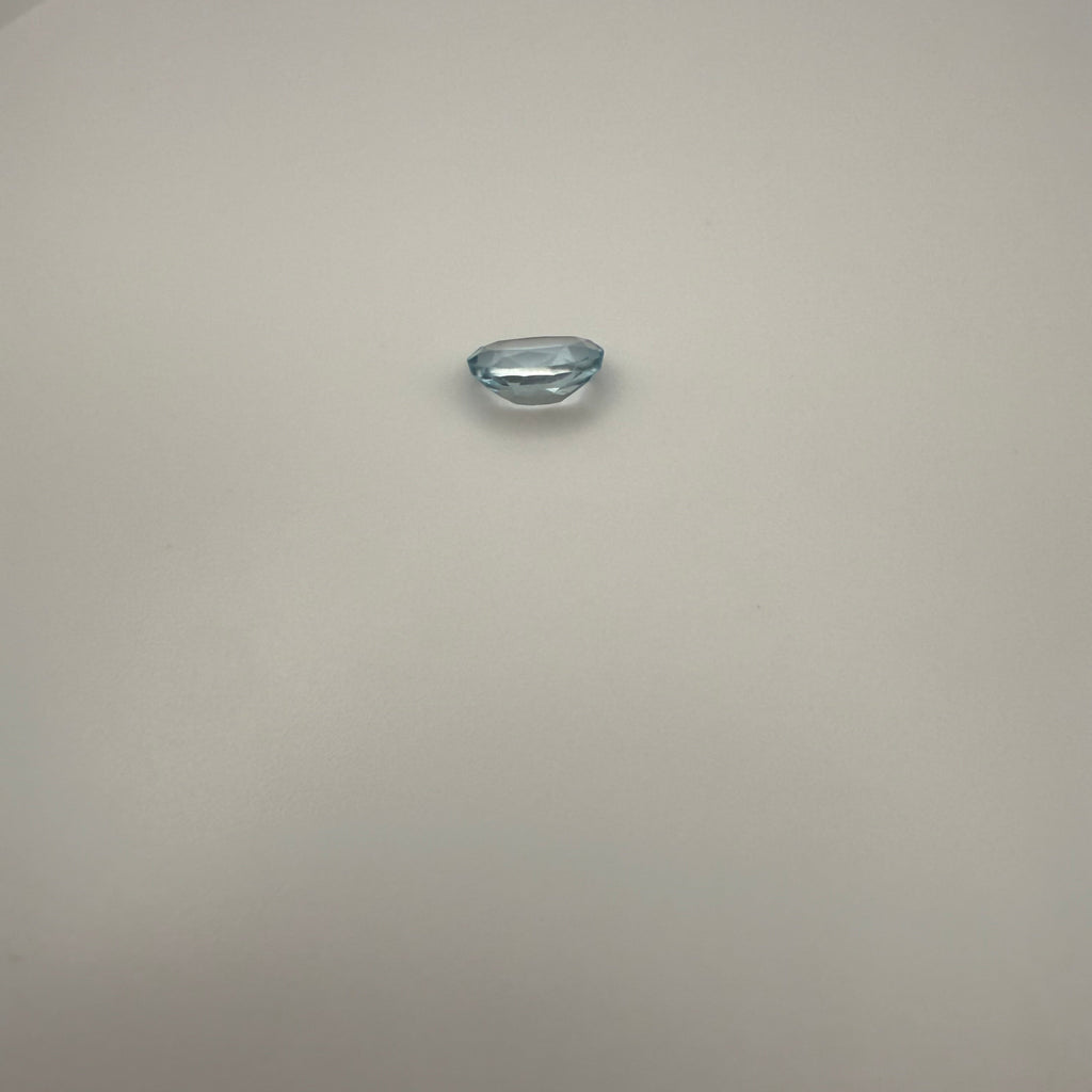 oval Swiss Blue Topaz gemstone on a light surface