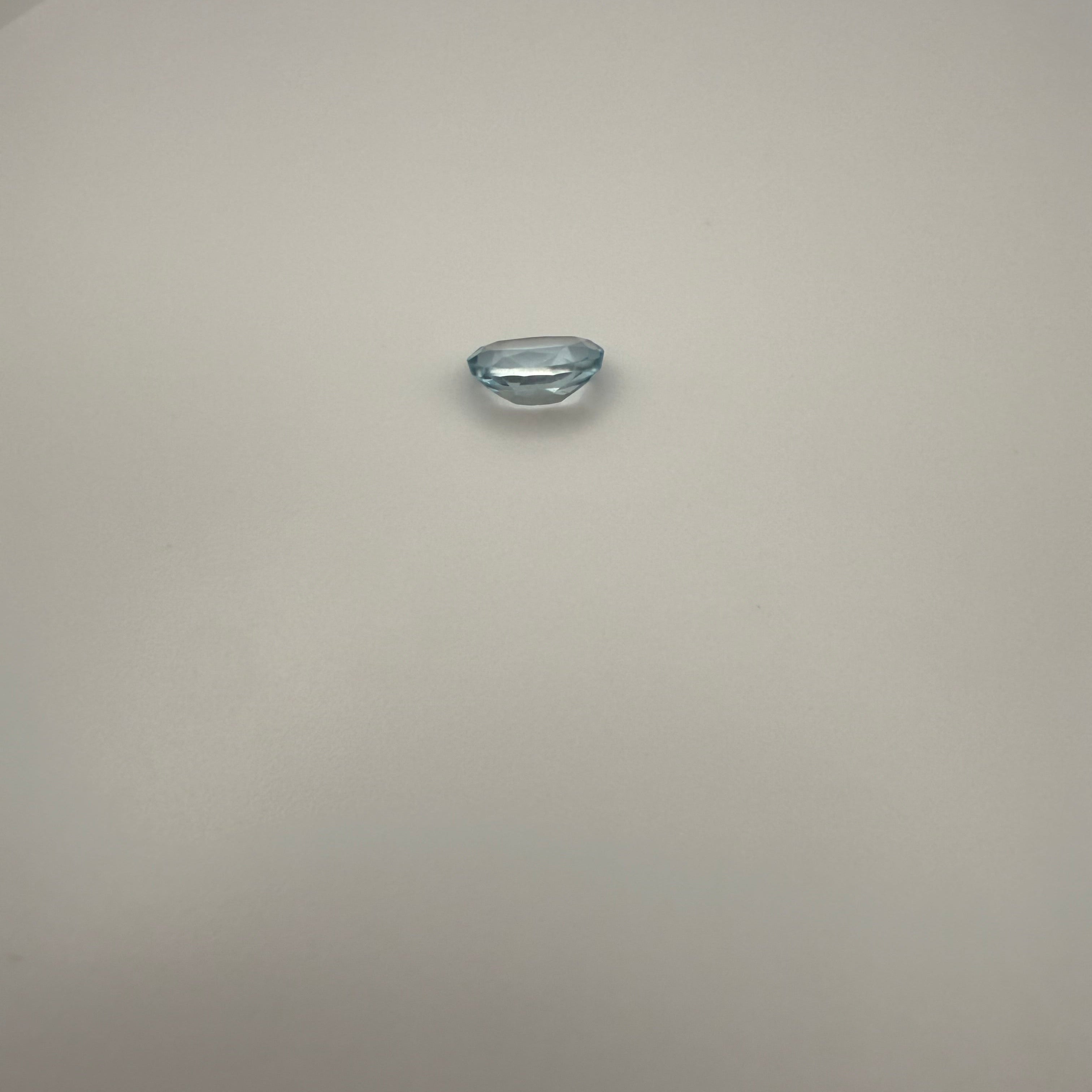 oval Swiss Blue Topaz gemstone on a light surface