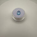 top down view of 2.0ct Swiss Blue Topaz pear faceted gemstone on purple cushion in clear gem holder on white background