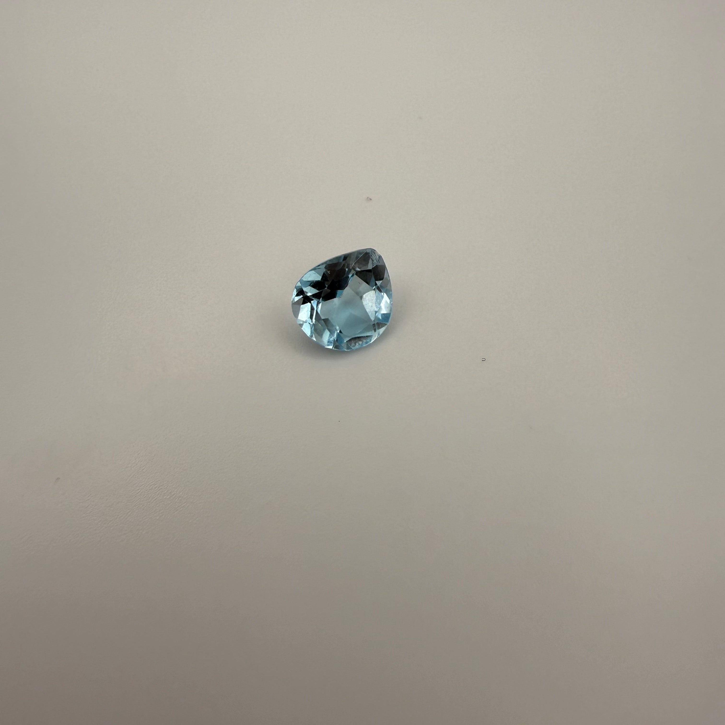 2.4ct Swiss Blue Topaz pear faceted gemstone on a neutral background