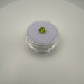 Round faceted 0.45ct yellow-green peridot gemstone displayed in a clear holder on soft surface