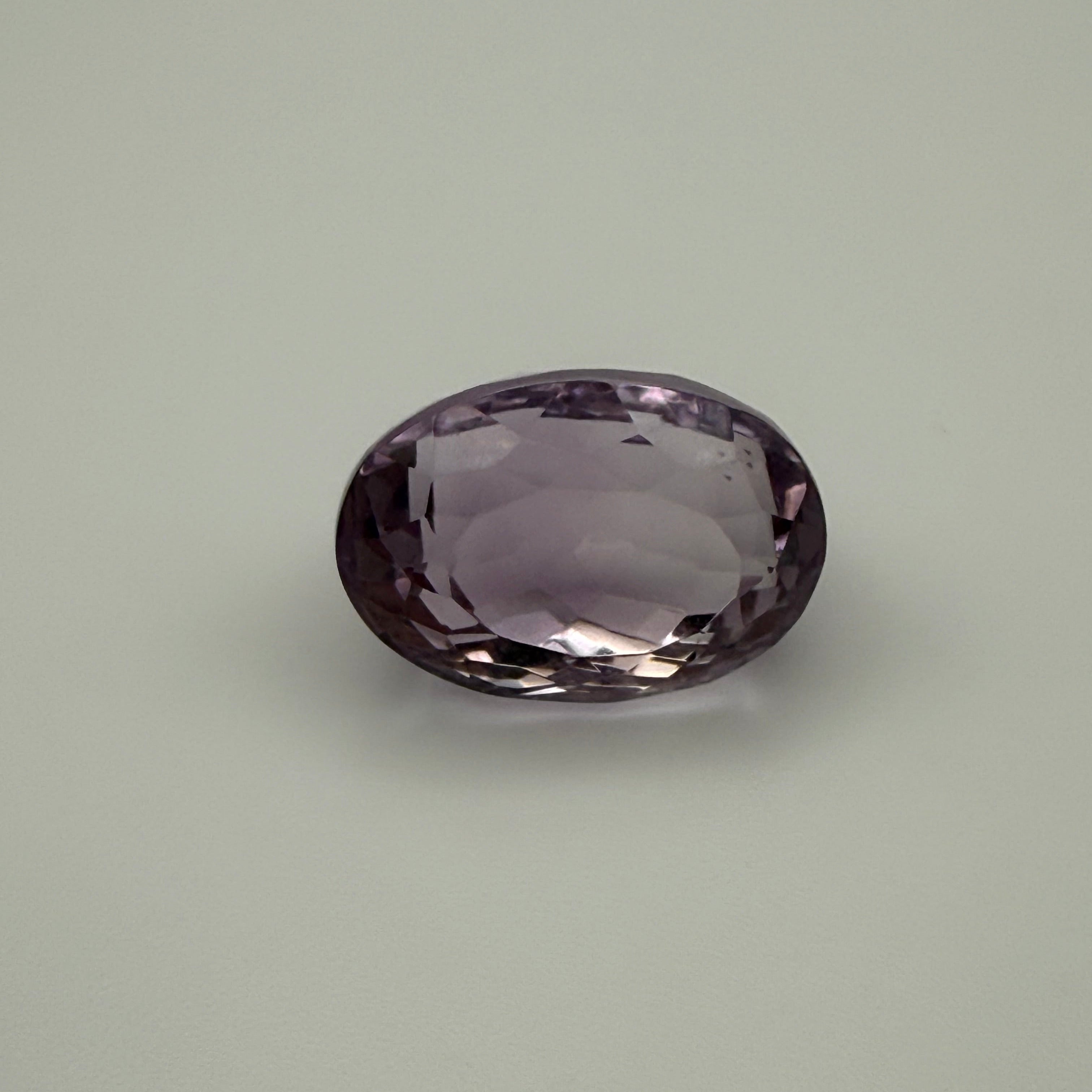 Purple gemstone on a light gray background