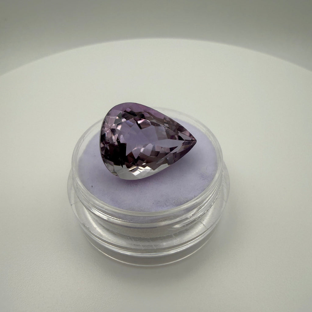 8.5ct Rose de France Amethyst pear faceted gemstone on soft purple display pad
