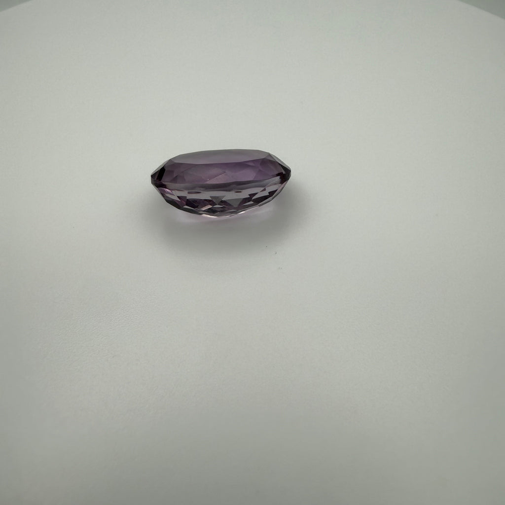 oval faceted 9.8ct lilac amethyst gemstone on a neutral background