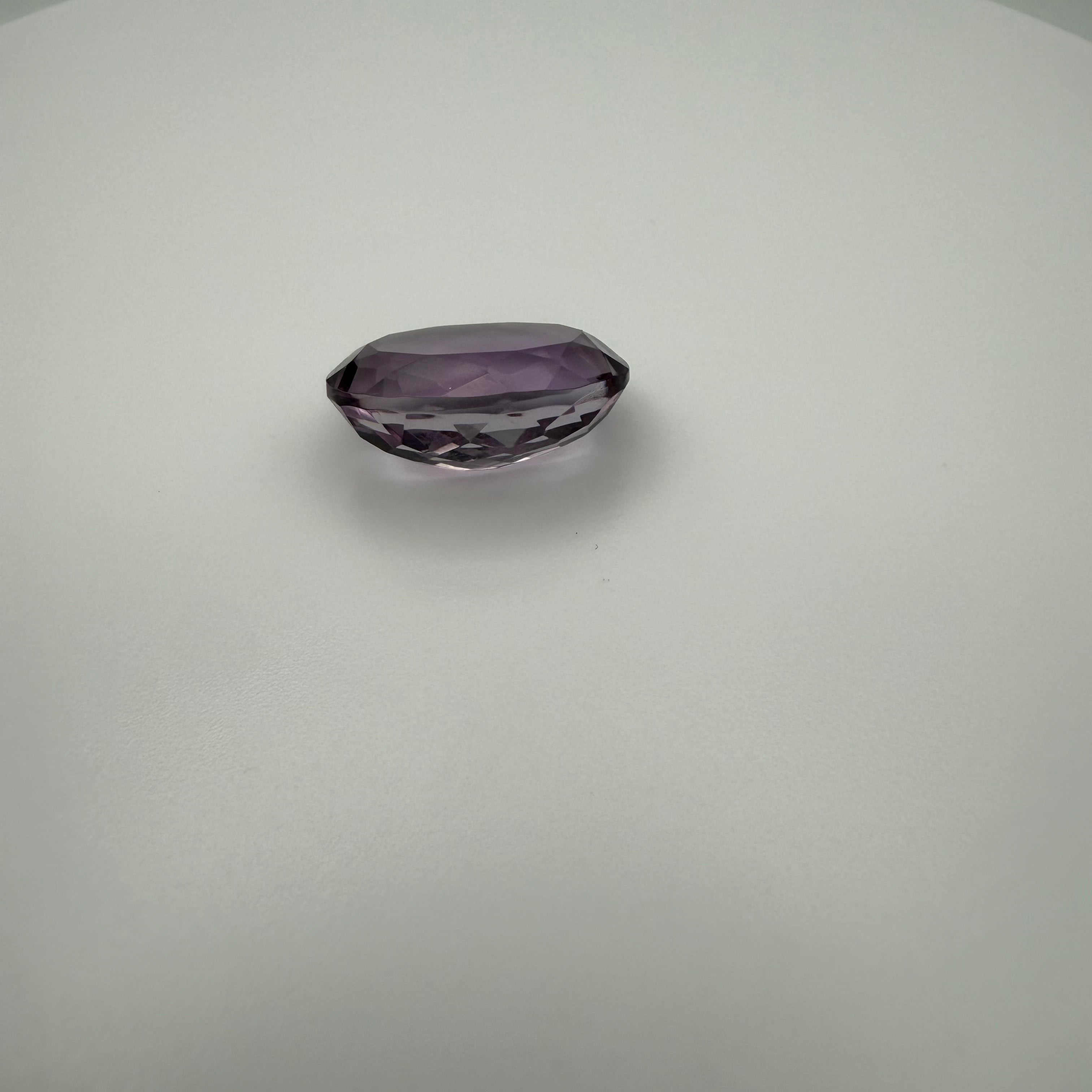 oval faceted 9.8ct lilac amethyst gemstone on a neutral background