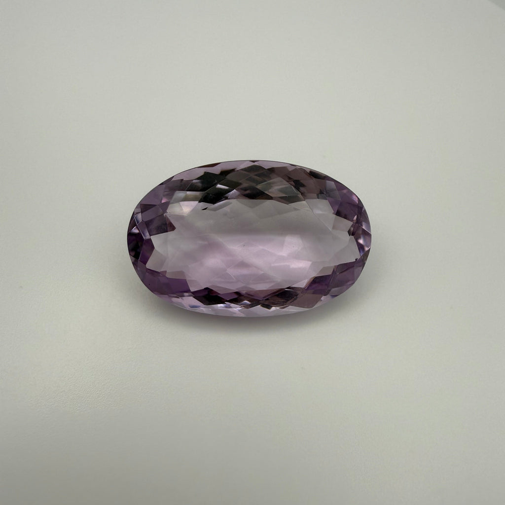 oval faceted 61.6ct Rose de France amethyst on light background