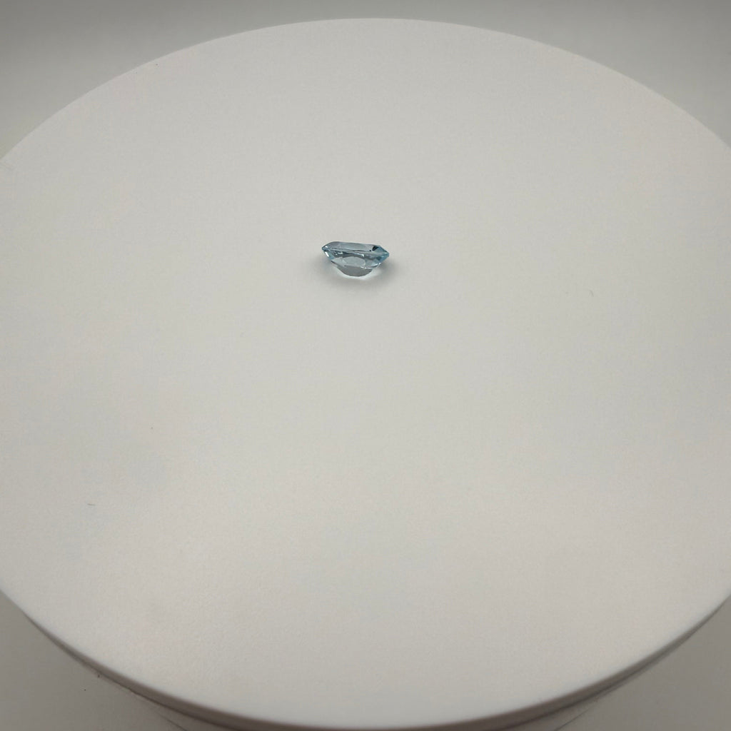 oval faceted 1.95ct Swiss Blue Topaz gemstone on a white circular display surface