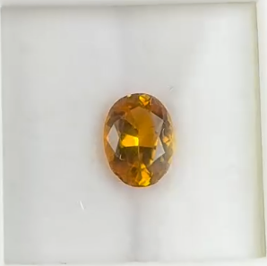 oval heated faceted canary yellow tourmaline gemstone on white background